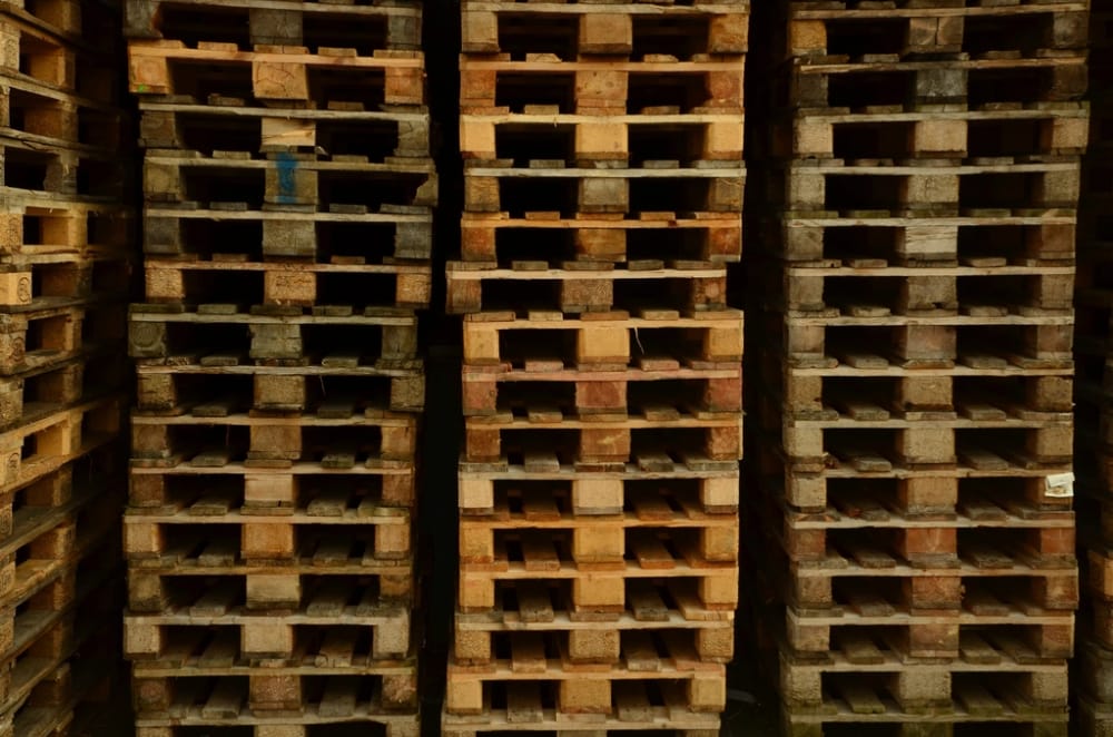 Stacks of euro pallets filling the frame in warm wood tones.